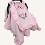 Pembe örgü pike kumaştan fırfırlı, kapaklı puset örtüsü; tül pencereli ve kişiselleştirilebilir nakış detaylı model.