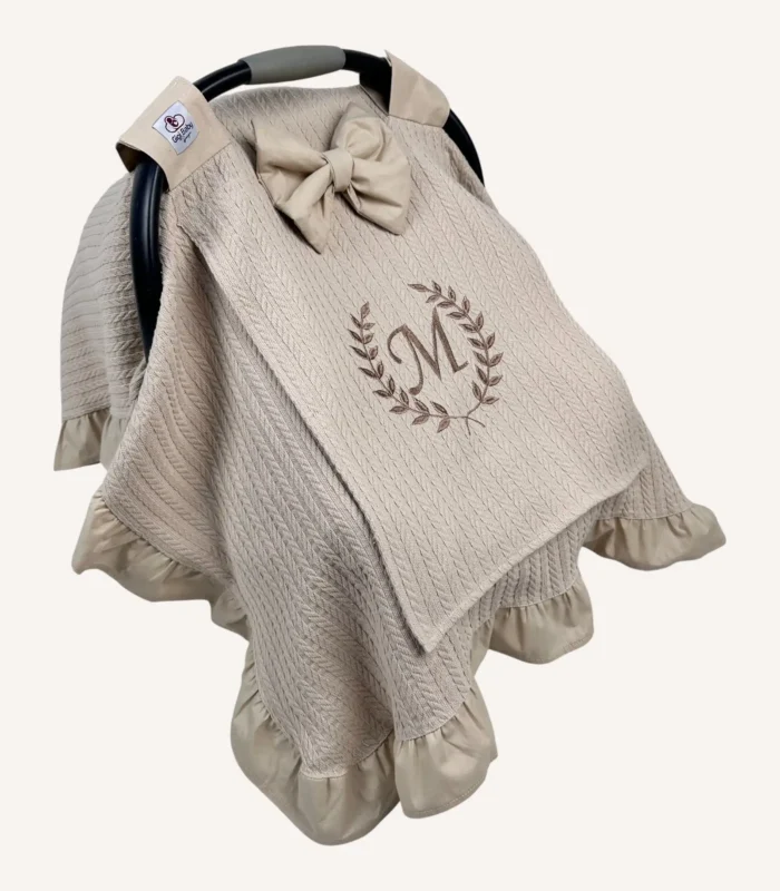 Bej örgü pike kumaştan, kenarları fırfırlı, kapak kısmı düz, kişiselleştirilebilir puset örtüsü.