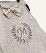 Bej örgü pike kumaştan, kenarları fırfırlı, kapak kısmı düz, kişiselleştirilebilir puset örtüsü.