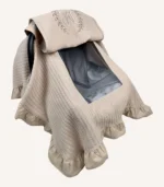 Bej örgü pike kumaştan, kenarları fırfırlı, kapak kısmı düz, kişiselleştirilebilir puset örtüsü.