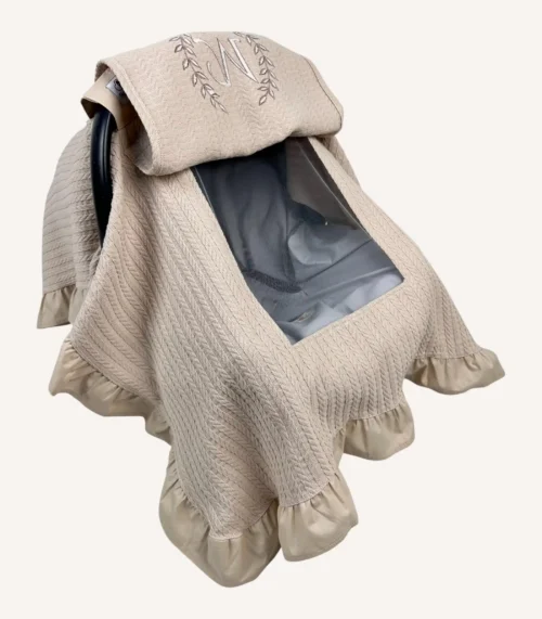 Bej örgü pike kumaştan, kenarları fırfırlı, kapak kısmı düz, kişiselleştirilebilir puset örtüsü.