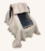 Bej tek kat müslin kumaştan fırfırlı, kapaklı puset örtüsü; tül pencereli ve kişiselleştirilebilir nakış detaylı model.