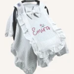 Beyaz örgü pike kumaştan fırfırlı, kapaklı puset örtüsü; tül pencereli ve kişiselleştirilebilir nakış detaylı model.