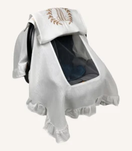 Beyaz tek kat müslin kumaştan fırfırlı, kapaklı puset örtüsü; tül pencereli ve kişiselleştirilebilir nakış detaylı model.