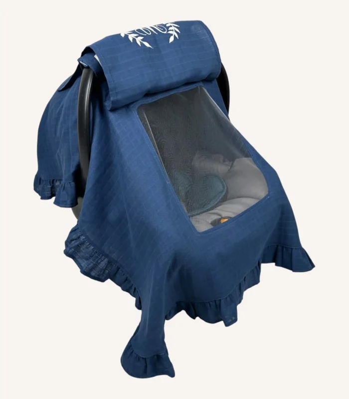 Denim mavi tek kat müslin kumaştan fırfırlı, kapaklı puset örtüsü; tül pencereli ve kişiselleştirilebilir nakış detaylı model.