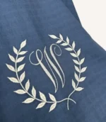 Denim mavi tek kat müslin kumaştan fırfırlı, kapaklı puset örtüsü; tül pencereli ve kişiselleştirilebilir nakış detaylı model.