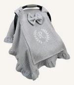 Gri örgü pike kumaştan, fırfırlı kenarlara sahip, fiyonklu kapaklı puset örtüsü.