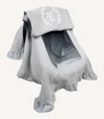 Gri örgü pike kumaştan, fırfırlı kenarlara sahip, fiyonklu kapaklı puset örtüsü.