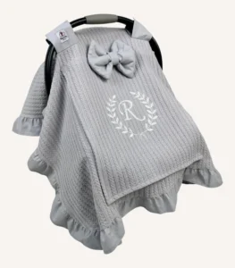 Gri örgü pike kumaştan, fırfırlı kenarlara sahip, fiyonklu kapaklı puset örtüsü.