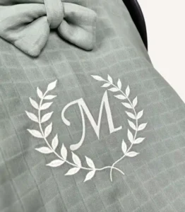 Haki tek kat müslin kumaştan fırfırlı, kapaklı puset örtüsü; tül pencereli ve kişiselleştirilebilir nakış detaylı model.