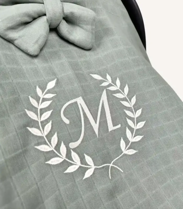 Haki tek kat müslin kumaştan fırfırlı, kapaklı puset örtüsü; tül pencereli ve kişiselleştirilebilir nakış detaylı model.