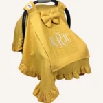 Hardal tek kat müslin kumaştan fırfırlı, kapaklı puset örtüsü; tül pencereli ve kişiselleştirilebilir nakış detaylı model.