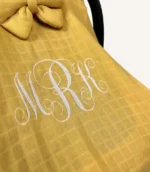 Hardal tek kat müslin kumaştan fırfırlı, kapaklı puset örtüsü; tül pencereli ve kişiselleştirilebilir nakış detaylı model.