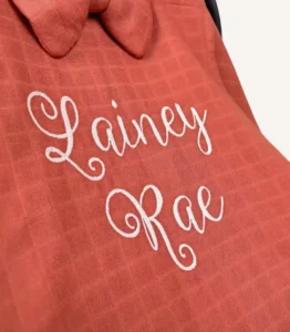 Kiremit tek kat müslin kumaştan fırfırlı, kapaklı puset örtüsü; tül pencereli ve kişiselleştirilebilir nakış detaylı model.