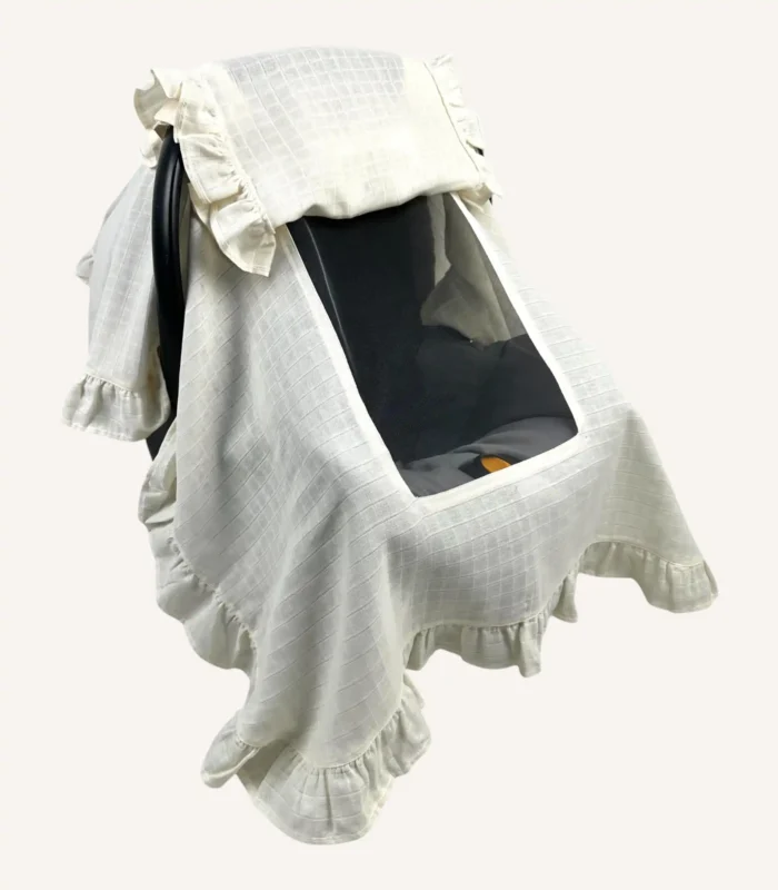 Krem tek kat müslin kumaştan, kapaklı ve kapak kenarları fırfırlı, tül pencereli, kişiselleştirilebilir puset örtüsü.