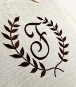 Krem tek kat müslin kumaştan fırfırlı, kapaklı puset örtüsü; tül pencereli ve kişiselleştirilebilir nakış detaylı model.