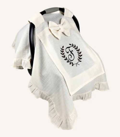 Krem tek kat müslin kumaştan fırfırlı, kapaklı puset örtüsü; tül pencereli ve kişiselleştirilebilir nakış detaylı model.