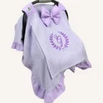 Lila örgü pike kumaştan, fırfırlı kenarlara sahip, fiyonklu kapaklı puset örtüsü.