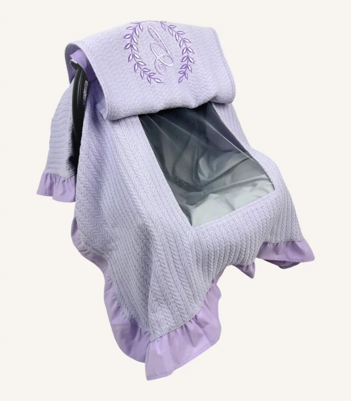 Lila örgü pike kumaştan, fırfırlı kenarlara sahip, fiyonklu kapaklı puset örtüsü.