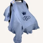 Mavi tek kat müslin kumaştan fırfırlı, kapaklı puset örtüsü; tül pencereli ve kişiselleştirilebilir nakış detaylı model.