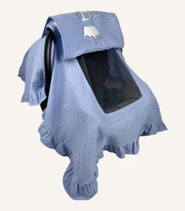 Mavi tek kat müslin kumaştan fırfırlı, kapaklı puset örtüsü; tül pencereli ve kişiselleştirilebilir nakış detaylı model.