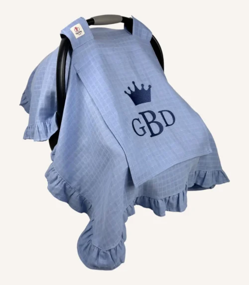 Mavi tek kat müslin kumaştan fırfırlı, kapaklı puset örtüsü; tül pencereli ve kişiselleştirilebilir nakış detaylı model.