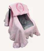 Pembe örgü pike kumaştan, fırfırlı kenarlara sahip, fiyonklu kapaklı puset örtüsü.