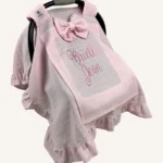 Pembe tek kat müslin kumaştan fırfırlı, kapaklı puset örtüsü; tül pencereli ve kişiselleştirilebilir nakış detaylı model.