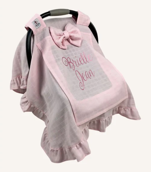 Pembe tek kat müslin kumaştan fırfırlı, kapaklı puset örtüsü; tül pencereli ve kişiselleştirilebilir nakış detaylı model.