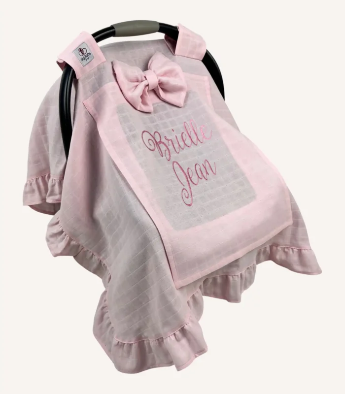 Pembe tek kat müslin kumaştan fırfırlı, kapaklı puset örtüsü; tül pencereli ve kişiselleştirilebilir nakış detaylı model.