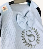 Bebek mavisi örgü pike kumaştan, sade kapaklı, tül pencereli ve fiyonklu puset örtüsü.