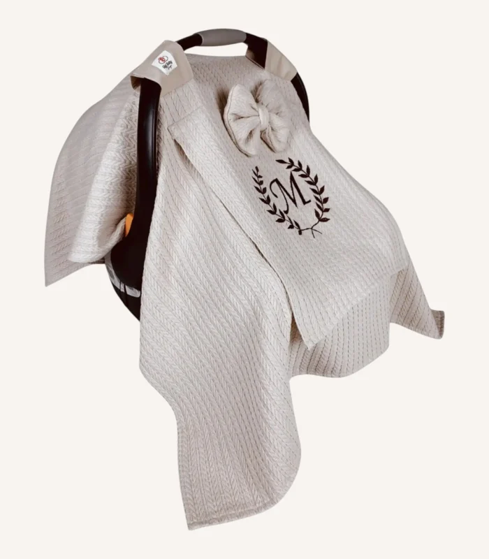 Bej örgü pike kumaştan, sade kapaklı, tül pencereli ve fiyonklu puset örtüsü.