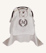 Bej örgü pike kumaştan, sade kapaklı, tül pencereli ve fiyonklu puset örtüsü.