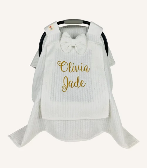 Beyaz örgü pike kumaştan, sade kapaklı, tül pencereli ve fiyonklu puset örtüsü.