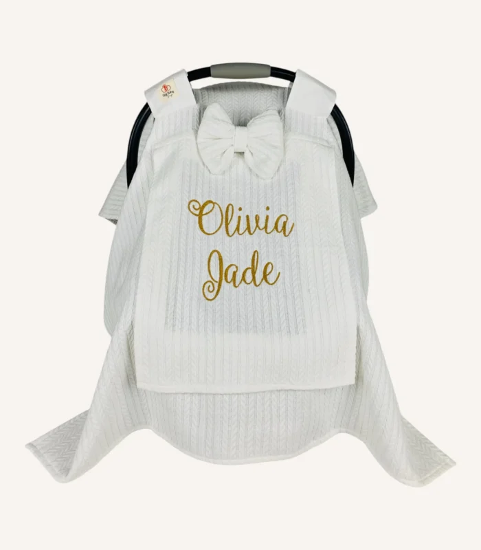 Beyaz örgü pike kumaştan, sade kapaklı, tül pencereli ve fiyonklu puset örtüsü.