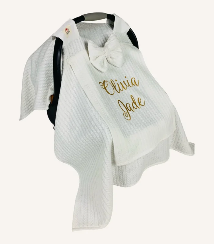 Beyaz örgü pike kumaştan, sade kapaklı, tül pencereli ve fiyonklu puset örtüsü.