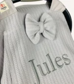 Gri örgü pike kumaştan, sade kapaklı, tül pencereli ve fiyonklu puset örtüsü.