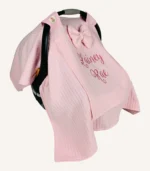 Pembe örgü pike kumaştan, sade kapaklı, tül pencereli ve fiyonklu puset örtüsü.