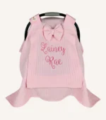 Pembe örgü pike kumaştan, sade kapaklı, tül pencereli ve fiyonklu puset örtüsü.