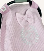 Pudra örgü pike kumaştan, sade kapaklı, tül pencereli ve fiyonklu puset örtüsü.