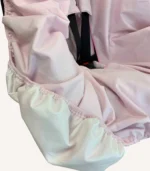 Pembe pamuk yüzeyli, alezli veya alezsiz seçenekli, çıtçıt kemer geçişli ve cırtlı kemer kılıflı çocuk oto koltuğu kılıfı