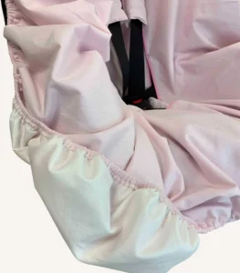 Pembe pamuk yüzeyli, alezli veya alezsiz seçenekli, çıtçıt kemer geçişli ve cırtlı kemer kılıflı çocuk oto koltuğu kılıfı