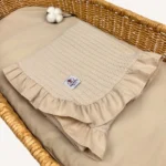 Bej örgü pike kumaştan fırfırlı, nakış seçenekli bebek battaniyesi