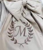 Bej örgü pike puset örtüsü, fiyonklu, ortadan yırtmaçlı çıtçıtlı model, fırfırlı kenarlı, %100 pamuk bebek puset örtüsü