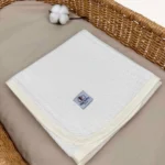 Krem örgü pike kumaştan biyeli, nakış seçenekli bebek battaniyesi