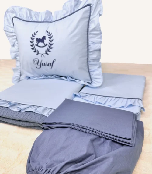 Bebek mavisi ve indigo mavi fırfırlı pamuklu bebek nevresim takımı, nakış detaylı dekoratif yastıklı set