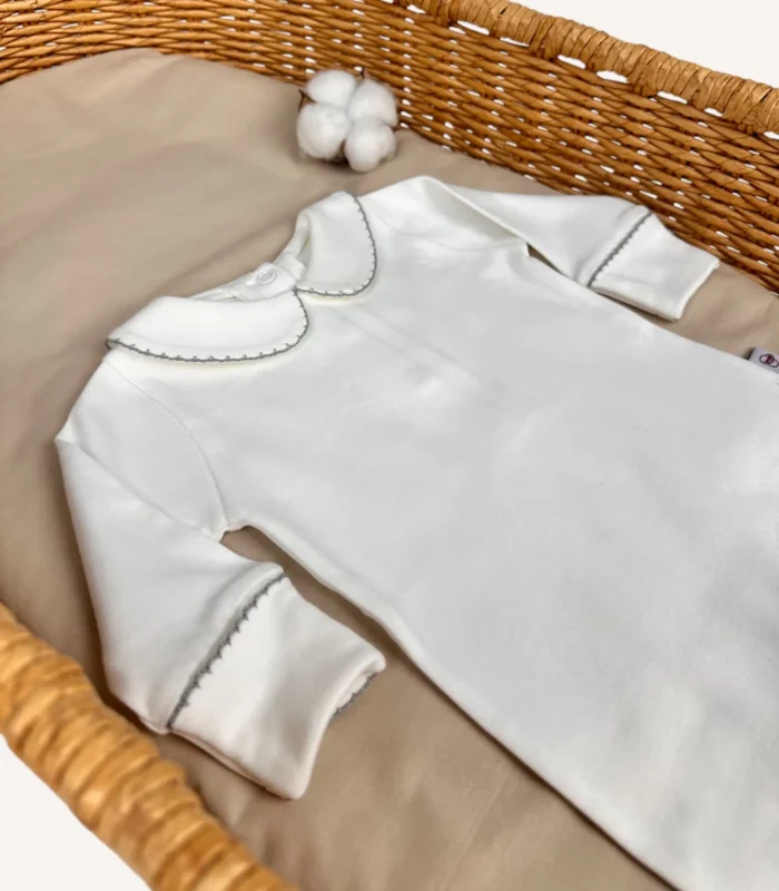 GOTS sertifikalı interlok kumaştan hazırlanan Organik Arkadan Çıtçıtlı Bebe Yakalı Kroşe İşlemeli Tulum, kroşe detaylı bebe yakası, kendinden eldivenli yapısı ve çift katlı patikleriyle prematüre ve 0-12 ay bebekler için tasarlanmıştır.